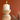 White candle in a wooden holder against an orange background